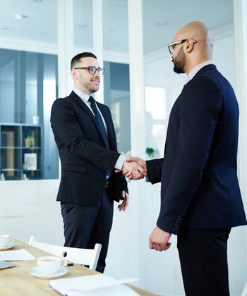 2 people shaking hands in an office